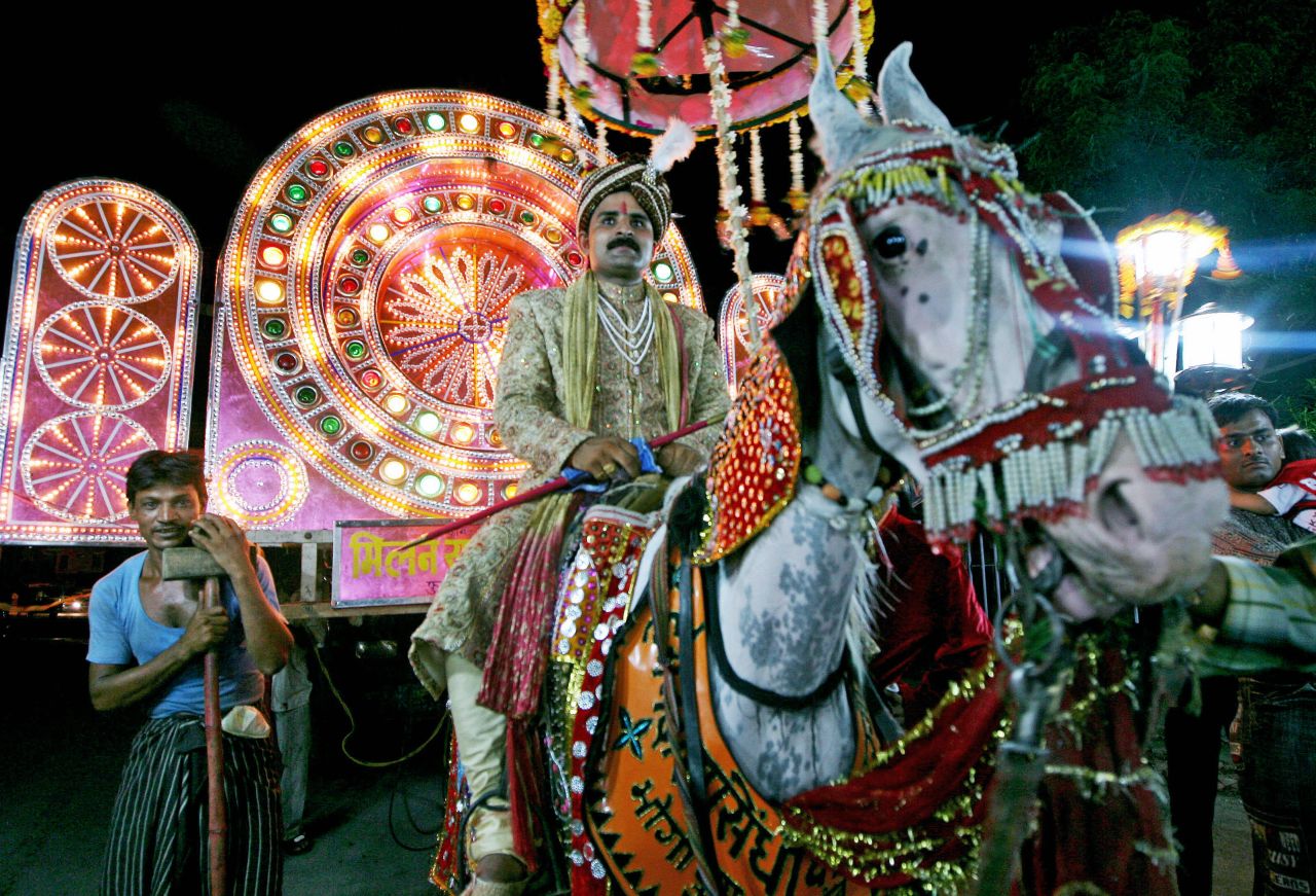 An Indian groom rides a horse on his way to his bride's house for their wedding ceremony in Agra in Uttar Pradesh.