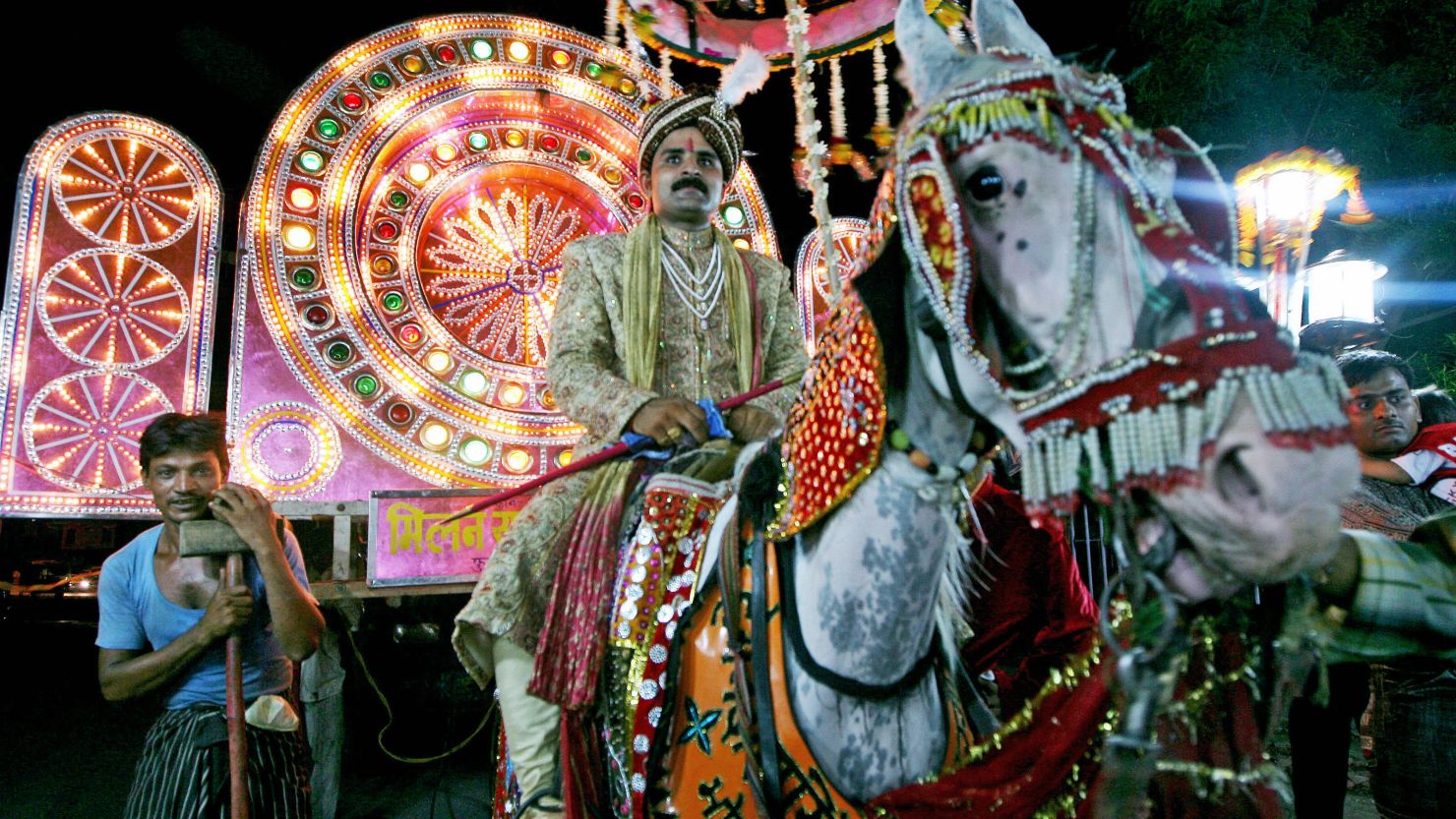 An Indian groom rides a horse on his way to his bride's house for their wedding ceremony.