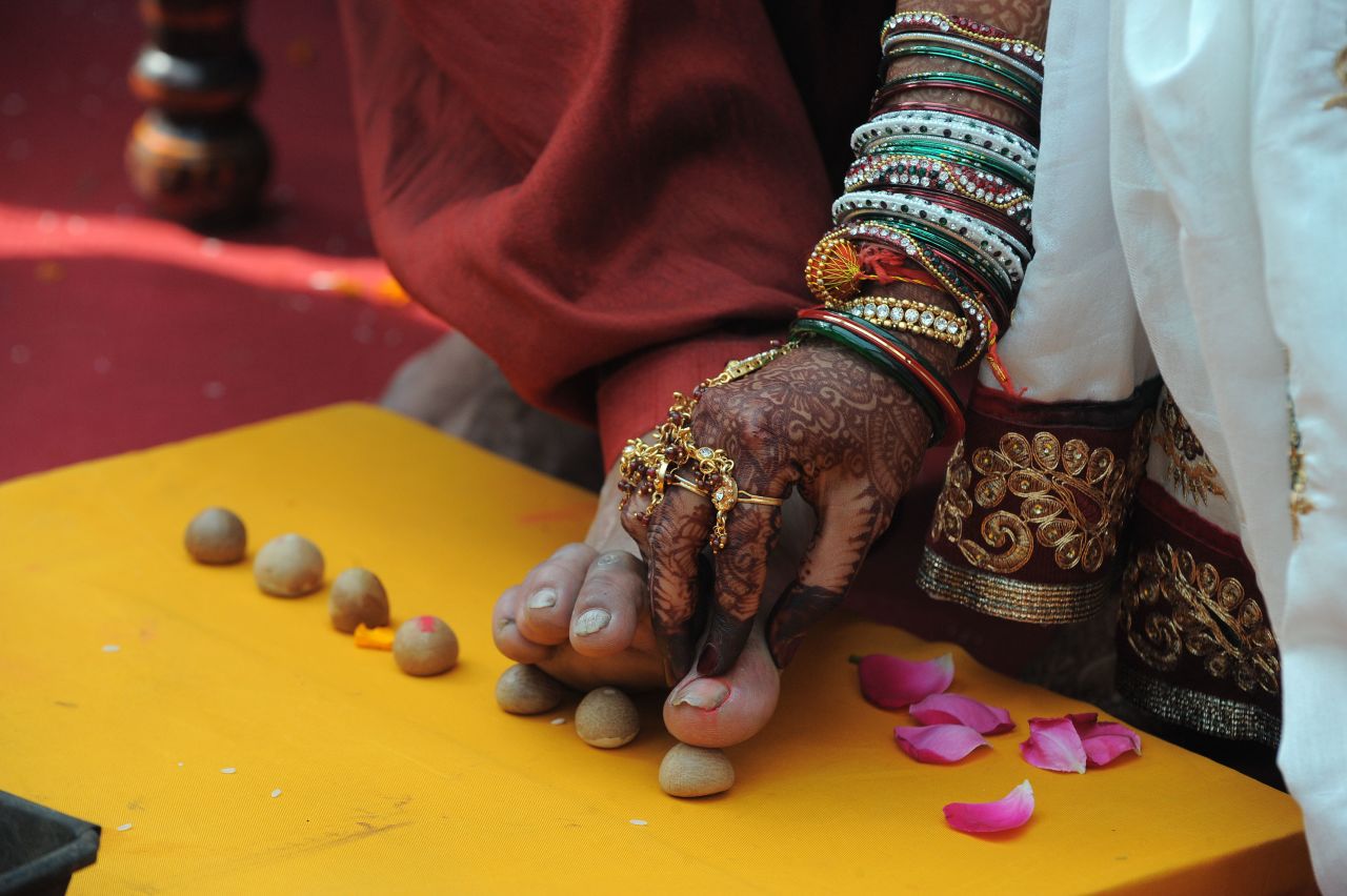 A couple participate in a ritual during a Jain mass wedding ceremony at the Karnawati Club in Ahmedabad, Gujarat.