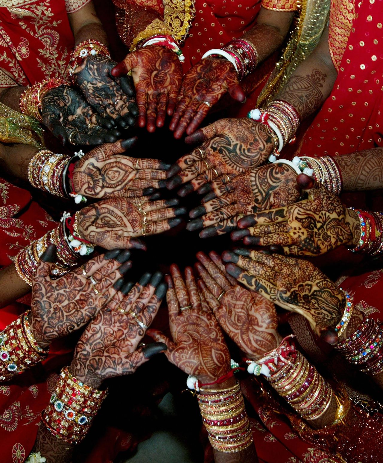 Indian brides display their hands, which have been decorated with henna in traditional bridal patterns, ahead of a multi-religious mass marriage in Bavla, Gujarat. 