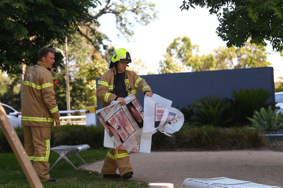 A firefighter is seen carrying a hazardous material bag into the South Korean consulate in Melbourne.