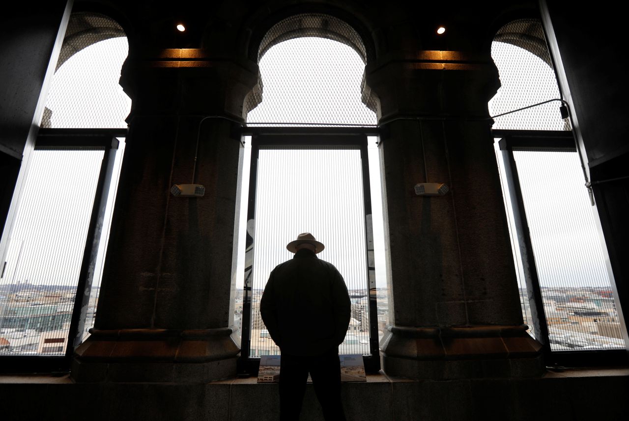 A National Park Service ranger looks out onto Washington from the Trump International Hotel's historic clock tower.