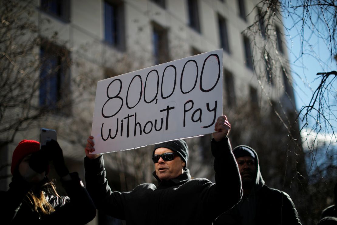 A demonstrator holds a sign, signifying hundreds of thousands of federal employees who won't be receiving their paychecks as a result of the partial government shutdown, during a "Rally to End the Shutdown" in Washington.