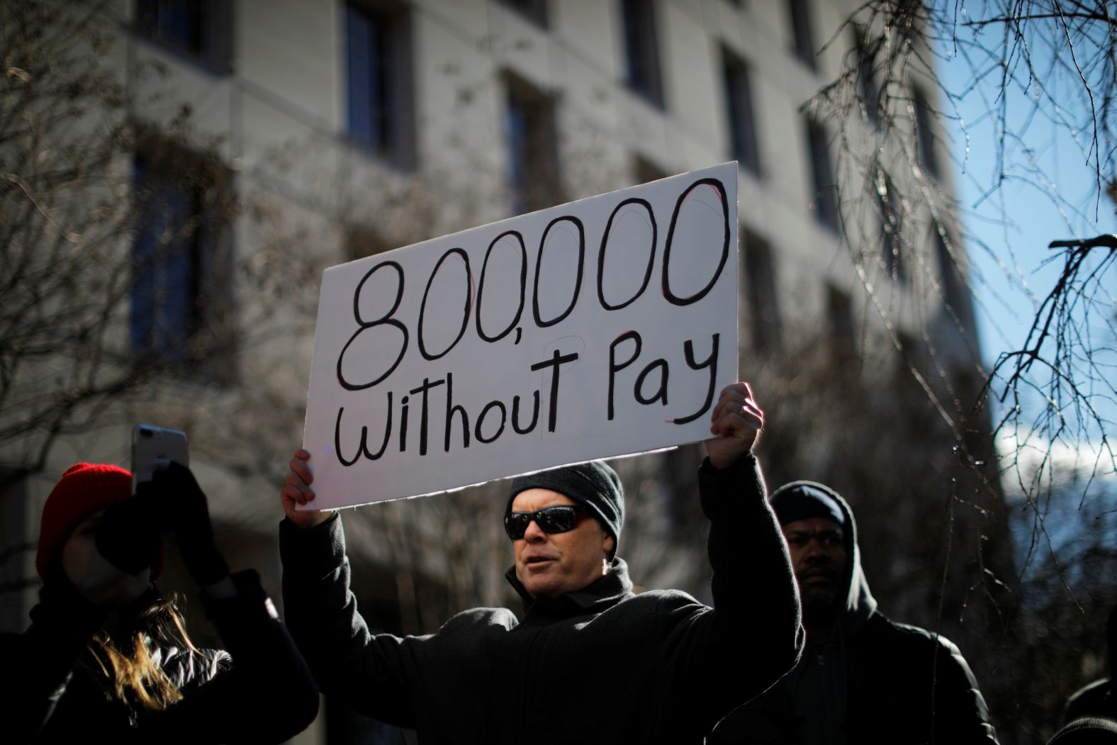 A protester holds a sign during a rally in Washington on January 10. Around 800,000 federal workers were out of work or were working without pay because of the shutdown. 
