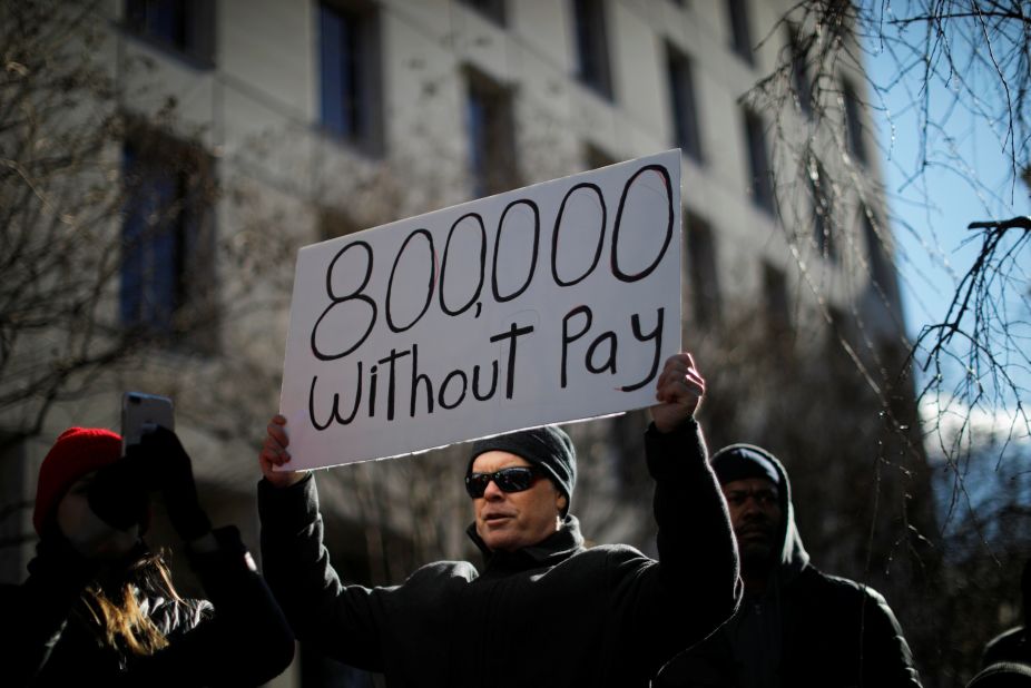 A protester holds a sign during a rally in Washington on January 10. Around 800,000 federal workers were out of work or were working without pay because of the shutdown. 