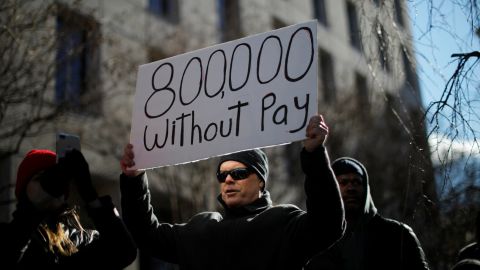 A demonstrator holds a sign, signifying hundreds of thousands of federal employees who won't be receiving their paychecks as a result of the partial government shutdown, during a "Rally to End the Shutdown" in Washington.