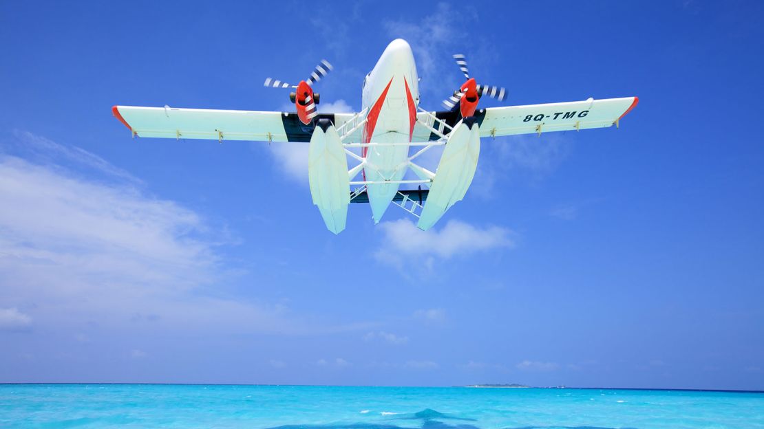 A Trans Maldivian Airways Twin Otter takes off from its watery runway.