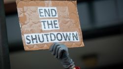 OGDEN, UT - JANUARY 10: A demonstrator holds a sign protesting the government shutdown at the James V. Hansen Federal Building on January 10, 2019 in Ogden, Utah. As the shutdown nears the three week mark, many federal employees will not receive a paycheck tomorrow.