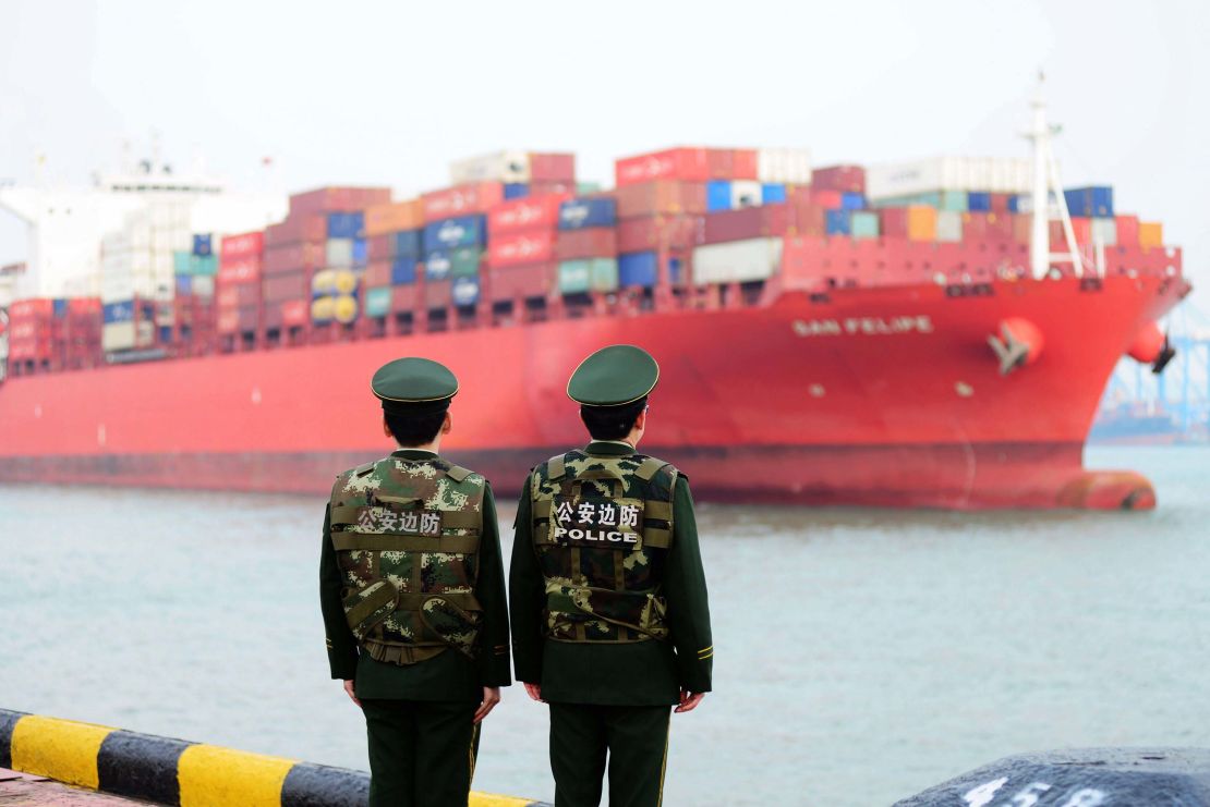 Police officers watching a cargo ship at a port in Qingdao in 2018. China's official growth rate for last year is expected to be around 6.5%, the weakest in nearly three decades.