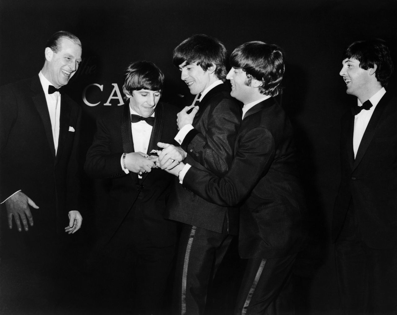 Prince Philip laughs as the Beatles fight over the Carl Alan Award he presented to the band in March 1964.