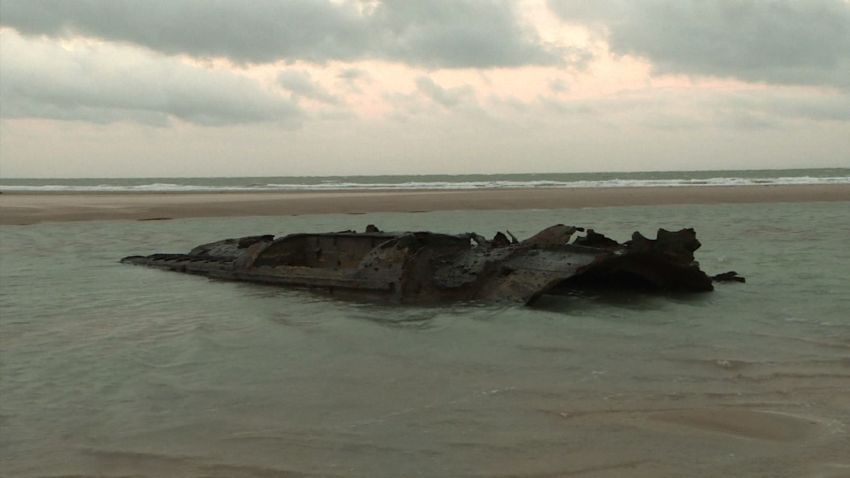 Parts of the UC 61 hull visible in shallow water during low tide in Wissant, France