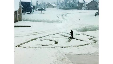 Ryan Hill of Lee's Summit, Missouri, shovels the Kansas City Chiefs' logo out of snow on his driveway. Despite the snow, an NFL playoff game between the Chiefs and the Indianapolis Colts will be played Saturday at Arrowhead Statdium in Kansas City.  