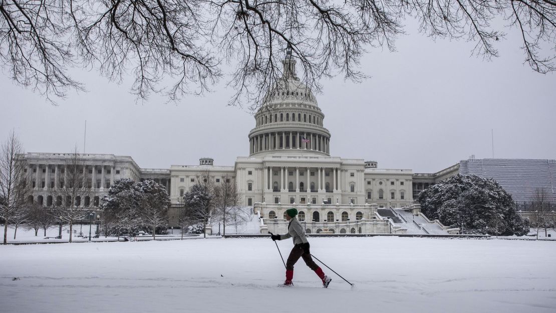 A woman cross country skis in front of the US Capitol as snow continues to fall in Washington, DC on January 13, 2019.
