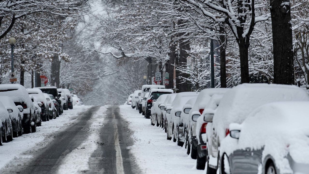 Snow covers parked cars during the winter storm in Washington.