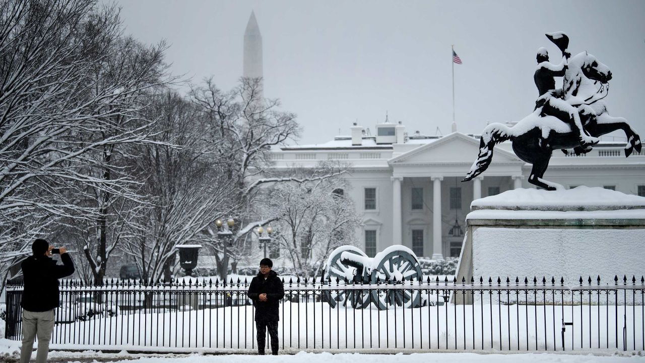 A tourist poses for a photo in Lafayette Square near the White House.