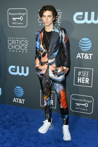 Timothee Chalamet paired a sleek, multi-colored suit by Alexander McQueen with white sneakers. 