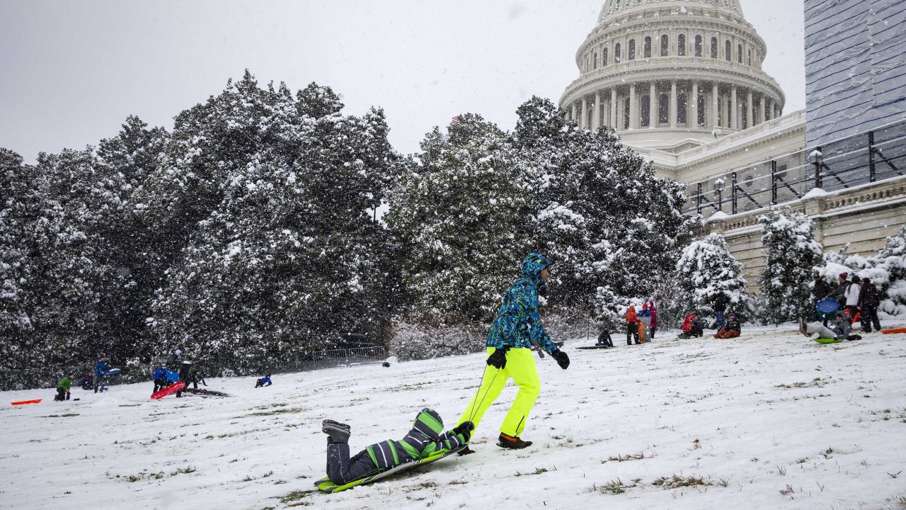 A man pulls his son up the hill as people sled on the west side of the US Capitol, on January 13, 2019, in Washington, DC. 