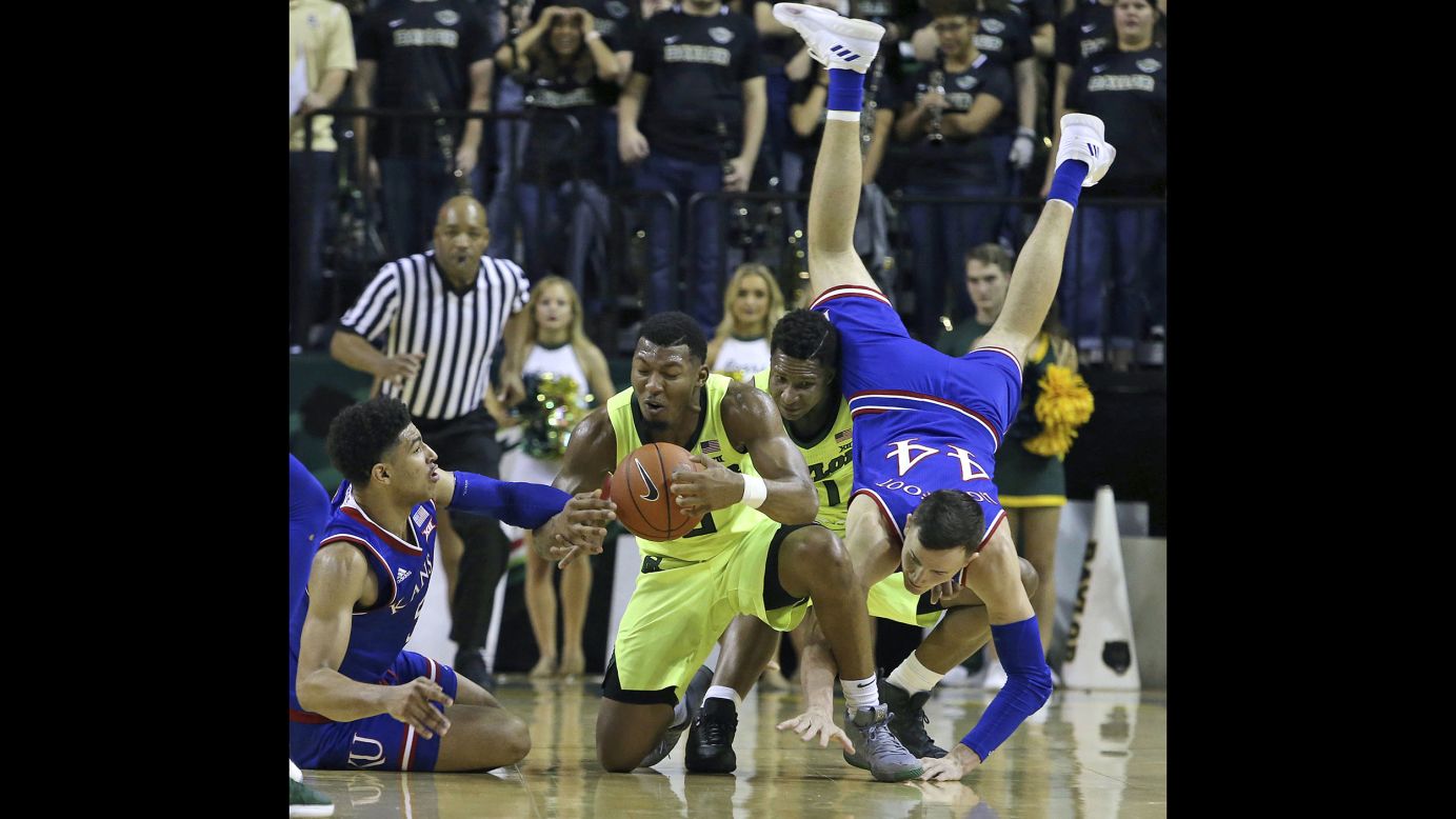 Baylor guard King McClure comes up with a loose ball against Kansas guard Quentin Grimes, left, as Kansas forward Mitch Lightfoot trips over Baylor guard Mark Vital in the first half of their game in Waco, Texas, on January 12.