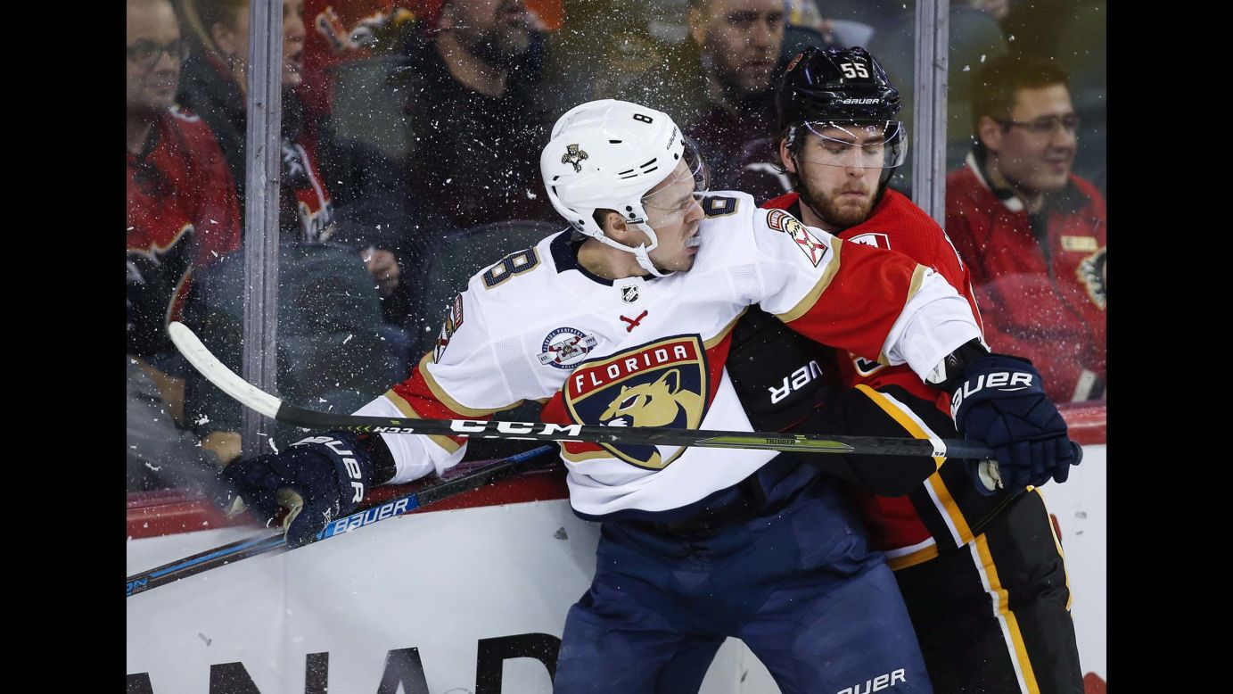 Florida Panthers' Jayce Hawryluk, left, is checked by Calgary Flames' Noah Hanifin during second-period NHL hockey game action in Calgary, Alberta, on January 11.