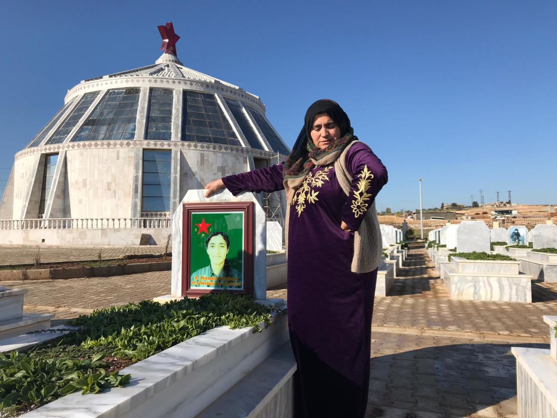 The mother of Peyman Tolhildan, 19, grieves by her grave in Kobani, northern Syria