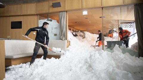 Emergency service workers clear snow from the inside a hotel on the Schwaegalp, Switzerland, after an avalanche.