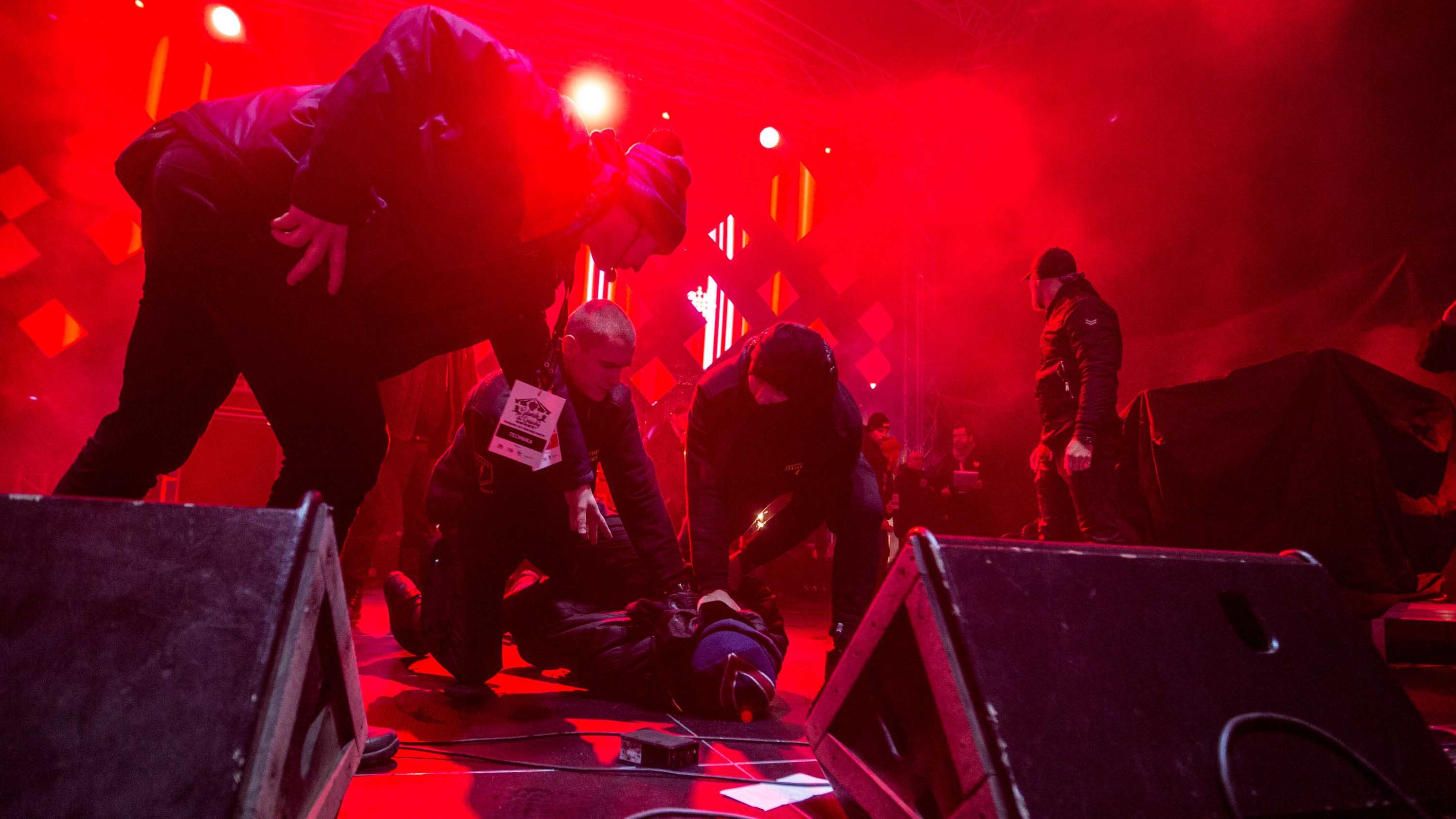 Security personnel hold down the suspect after he attacked Adamowicz.