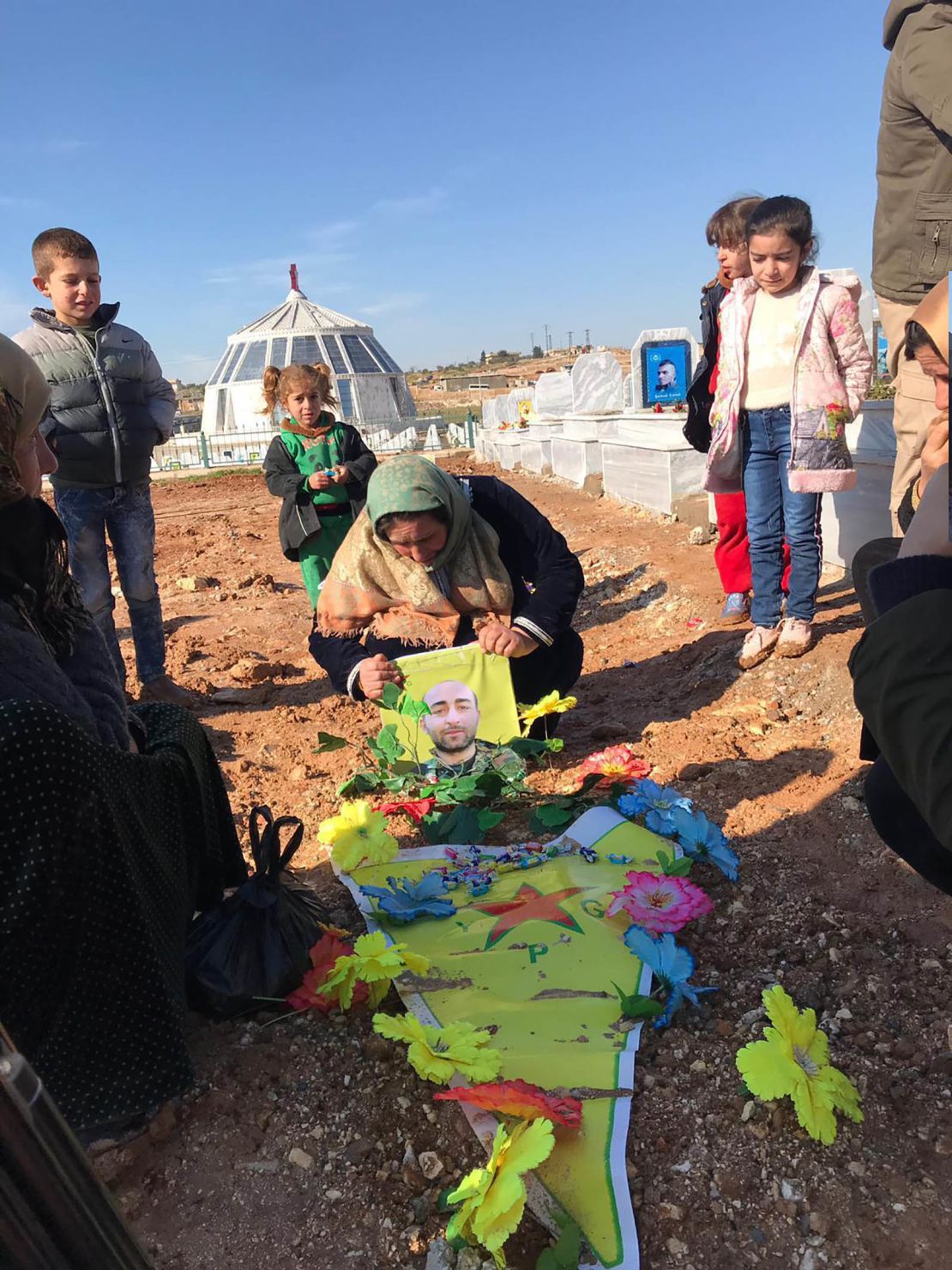 The family of 27-year-old Mahmoud Rassoul grieve by his grave in Kobani, northern Syria.