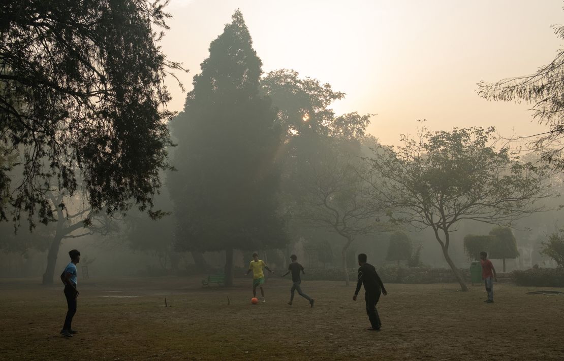 Indian youths play football amid air pollution smog at Lodhi Gardens in New Delhi on January 12, 2019. 