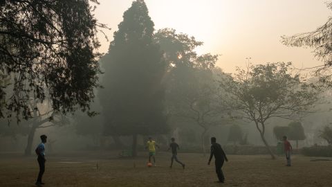 Indian youths play football amid air pollution smog at Lodhi Gardens in New Delhi on January 12, 2019. 
