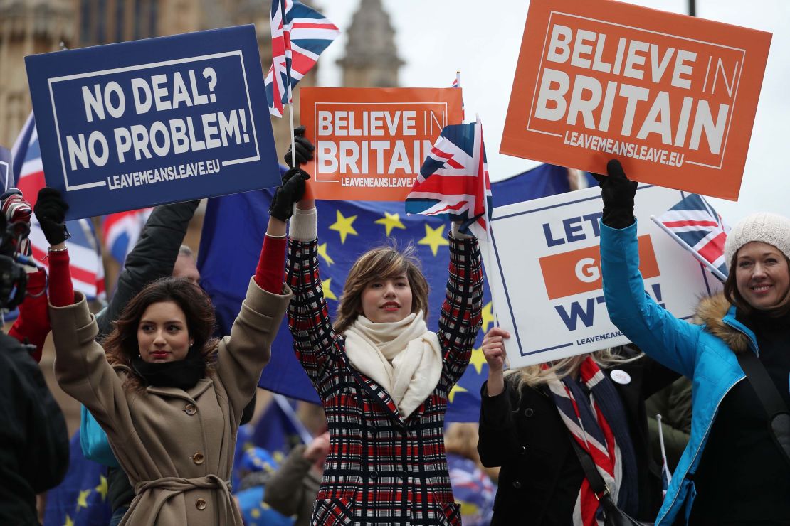 Pro-Brexit supporters hold up placards outside the UK Parliament as MPs debated.