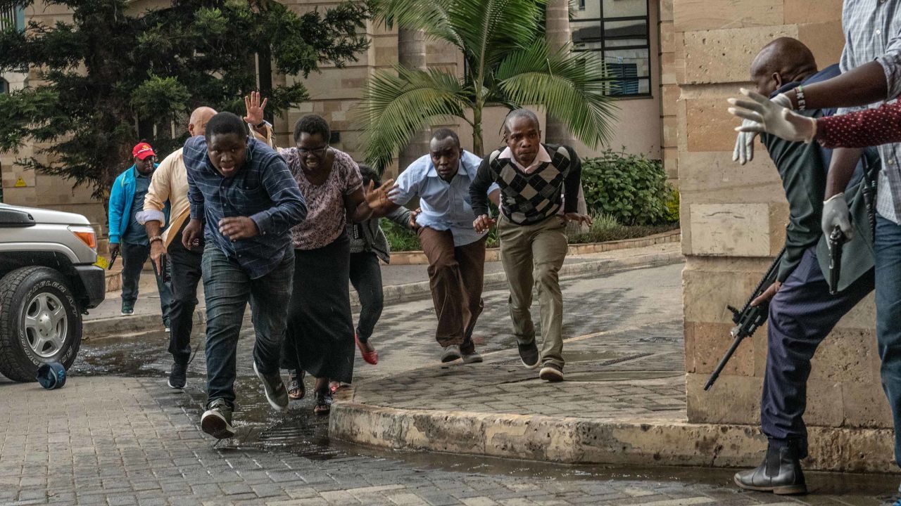 People run for cover after being rescued from the compound.