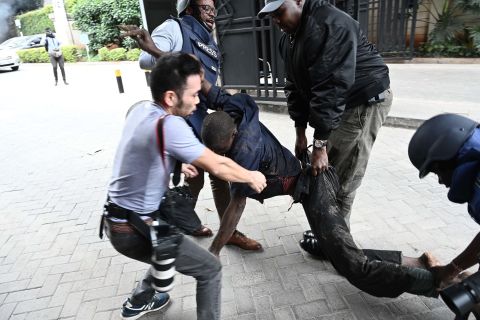 Journalists carry a victim from the scene of an explosion.