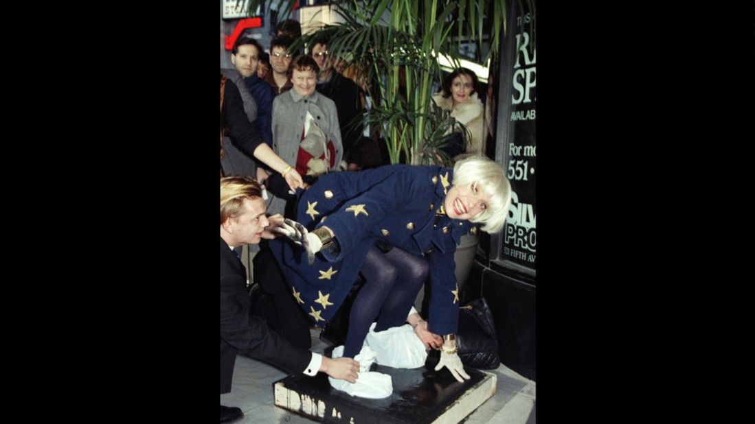 Channing places her feet in wet cement in front of the Embassy Suites Hotel in New York in November 1990 as part of an unveiling ceremony at the hotel.