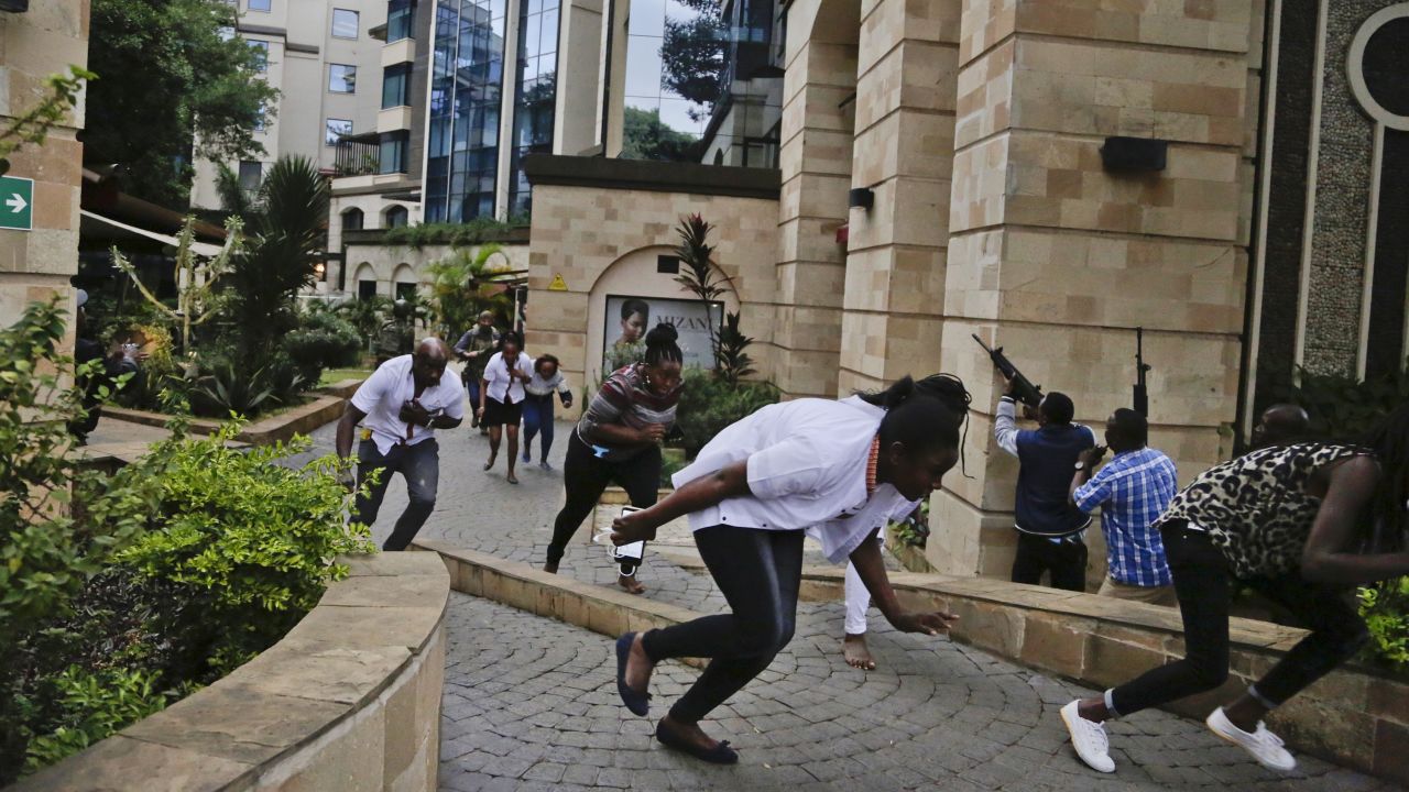 Civilians flee as security forces work to clear the buildings of a hotel complex in Nairobi during the deadly attack.
