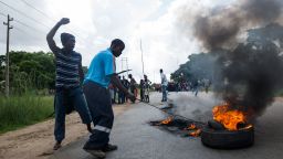 A man sets tyre on fire as angry protesters barricade the main route to Zimbabwe's capital Harare from Epworth township on January 14 2019 after announced a more than hundred percent hike in fuel prices.