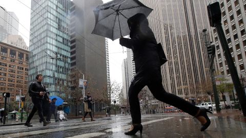 A woman carries an umbrella while crossing a street in San Francisco on Tuesday.