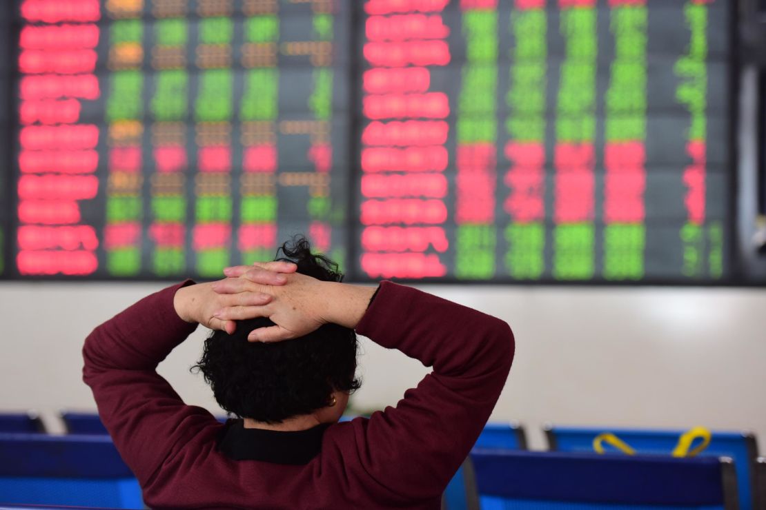 An investor watching the electronic board at a stock exchange hall in Fuyang, China. On Wednesday morning, the Shanghai Composite was trading largely flat. 