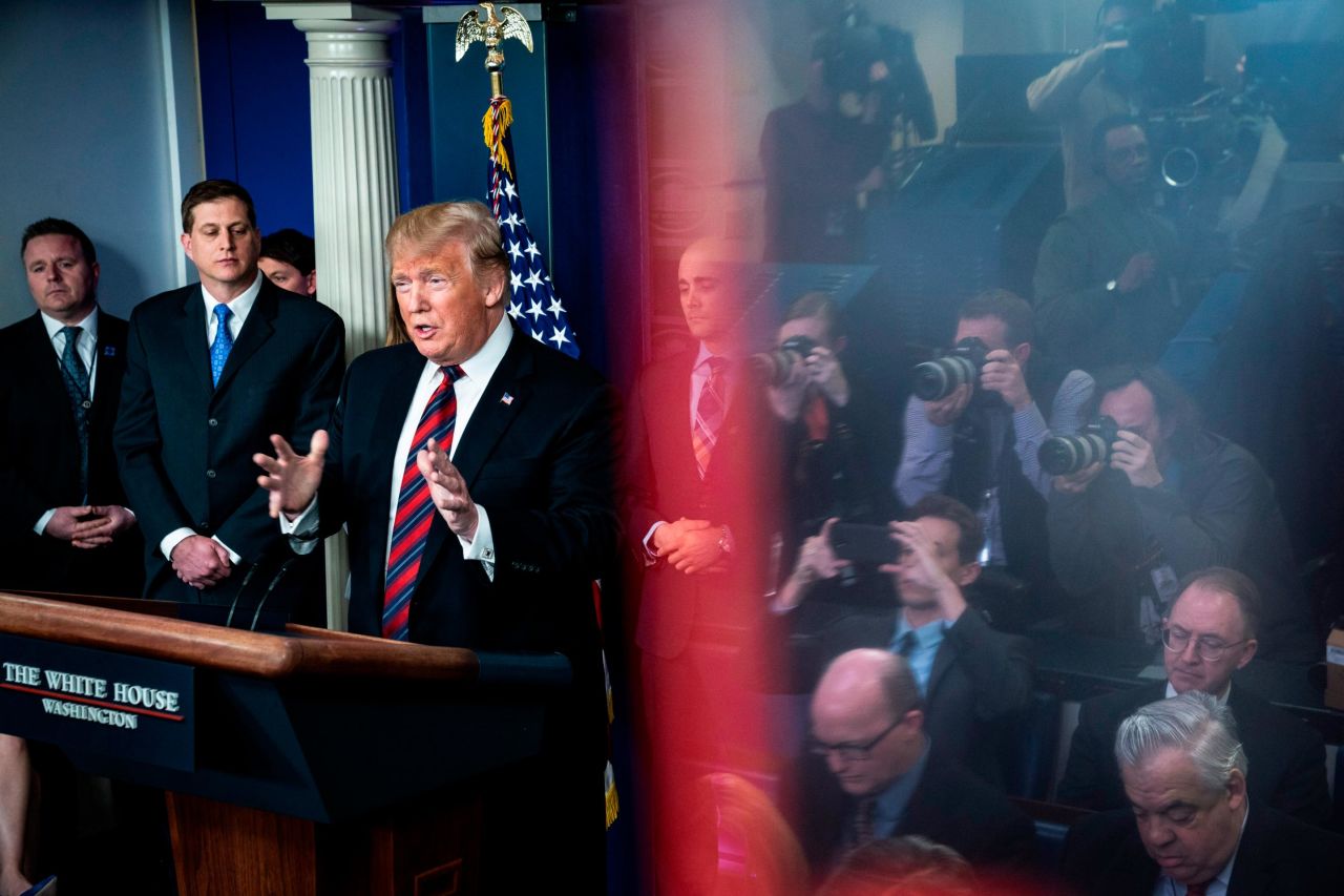 Reporters are seen reflected in an exit sign as President Trump <a href="https://www.cnn.com/politics/live-news/first-white-house-press-briefing-2019/h_545927a35316e9fadf3ad07999ea8904" target="_blank">speaks for the first time at a White House press briefing</a> on January 3. The President introduced three Border Patrol Council members who spoke about the need for a border wall.