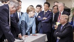 CHARLEVOIX, CANADA - JUNE 9:   In this photo provided by the German Government Press Office (BPA), German Chancellor Angela Merkel deliberates with US president Donald Trump on the sidelines of the official agenda on the second day of the G7 summit on June 9, 2018 in Charlevoix, Canada. Also pictured are (L-R) Larry Kudlow, director of the US National Economic Council, Theresa May, UK prime minister, Emmanuel Macron, French president, Angela Merkel, Yasutoshi Nishimura, Japanese deputy chief cabinet secretary, Shinzo Abe, Japan prime minister, Kazuyuki Yamazaki, Japanese senior deputy minister for foreign affairs, John Bolton, US national security adviser, and Donald Trump. Canada are hosting the leaders of the UK, Italy, the US, France, Germany and Japan for the two day summit. (Photo by Jesco Denzel /Bundesregierung via Getty Images)