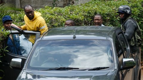 Zimbabwean cleric and activist Evan Mawarire (2nd L) enters in a police car under the supervision of policemen on January 16, 2019, after he was picked up from his home in Avondale, Harare. 