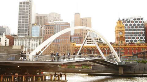 Melbourne's neighborhoods are a big selling point. Here, people cross a pedestrian bridge in popular Southbank.