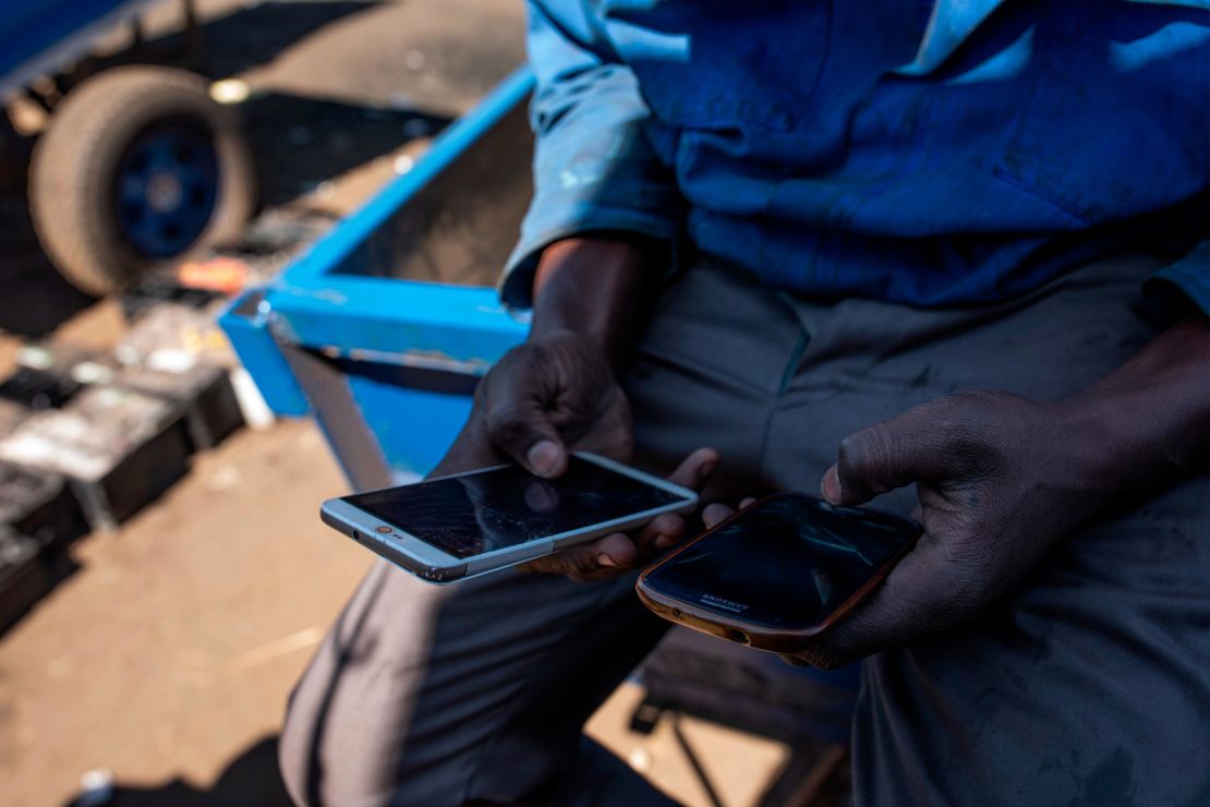 A man checks his mobile phones in the Mbare neighborhood in Harare, Zimbabwe. A social media shutdown has affected the whole country. 