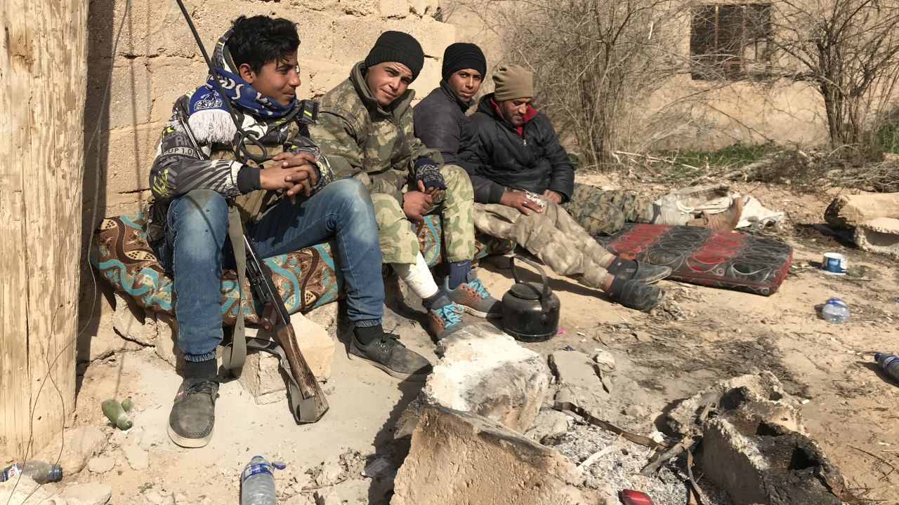 Syrian Democratic Forces (SDF) troops take a break between the town of Sha'fa and Soussa, one of the last ISIS-controlled villages in southeast Syria.