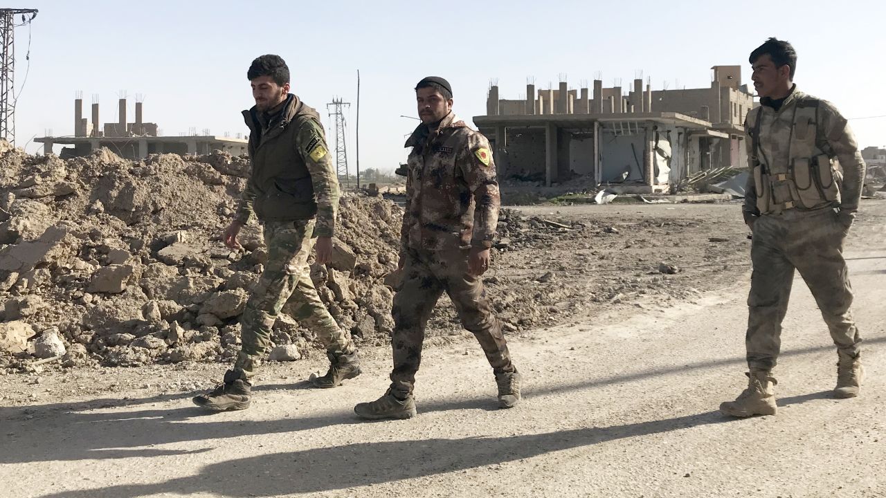 Three SDF soldiers in the southeast Syrian town of Hajin after it was liberated from ISIS.