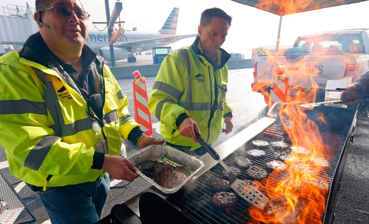 Airport operation workers flip burgers and hot dogs at Salt Lake City International Airport on January 16. They treated federal workers to a free lunch.