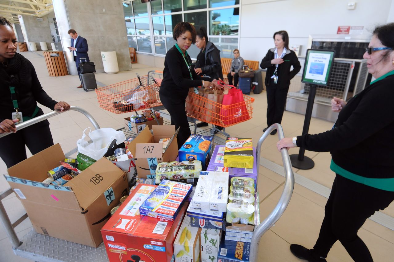 Employees of Frontier Airlines bring donated food for federal workers to Orlando International Airport on Wednesday, January 16.