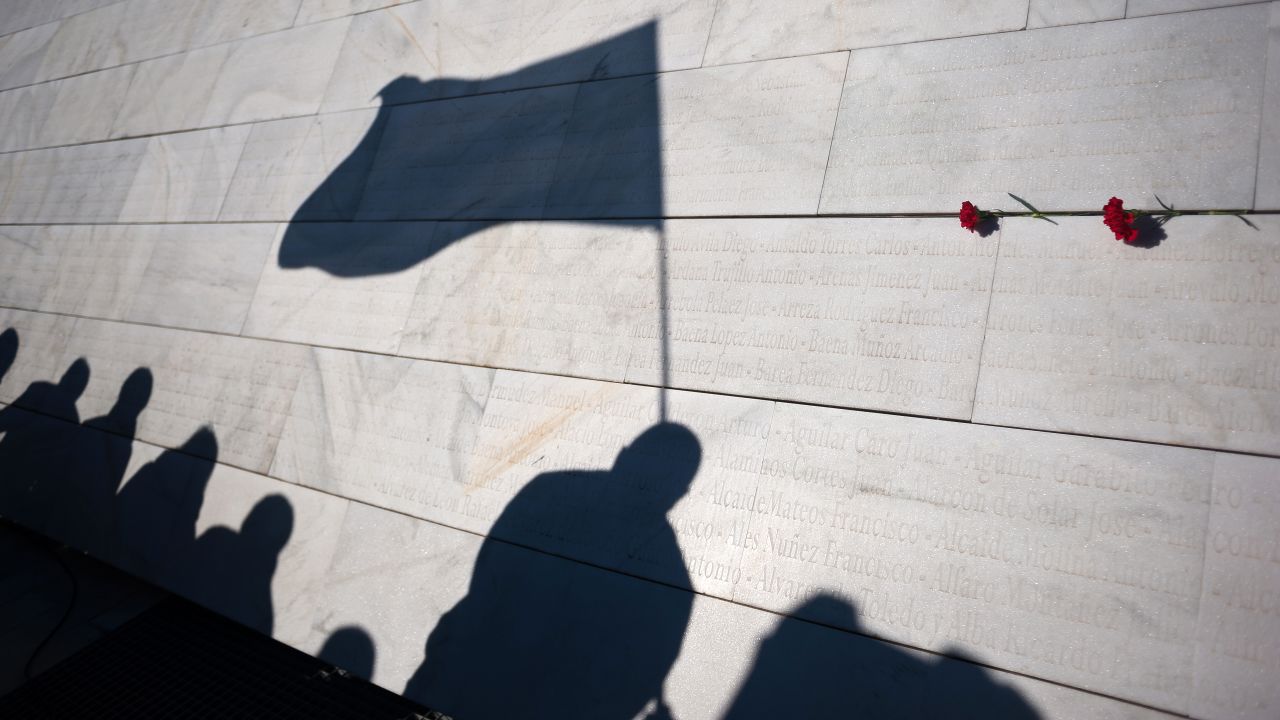 A silhouette of a man seen with a flag is cast against a memorial mausoleum on Saturday, January 12, in Malaga, Spain, during a tribute to republicans killed during the civil war by forces of Spanish dictator Francisco Franco.