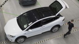 An employee passes a new Tesla Model X sports utility vehicle (SUV) following assembly for the European market at the Tesla Motors Inc. factory in Tilburg, Netherlands, on Friday, Dec. 9, 2016. A boom in electric vehicles made by the likes of Tesla could erode as much as 10 percent of global gasoline demand by 2035, according to the oil industry consultant Wood Mackenzie Ltd. Photographer: Jasper Juinen/Bloomberg via Getty Images