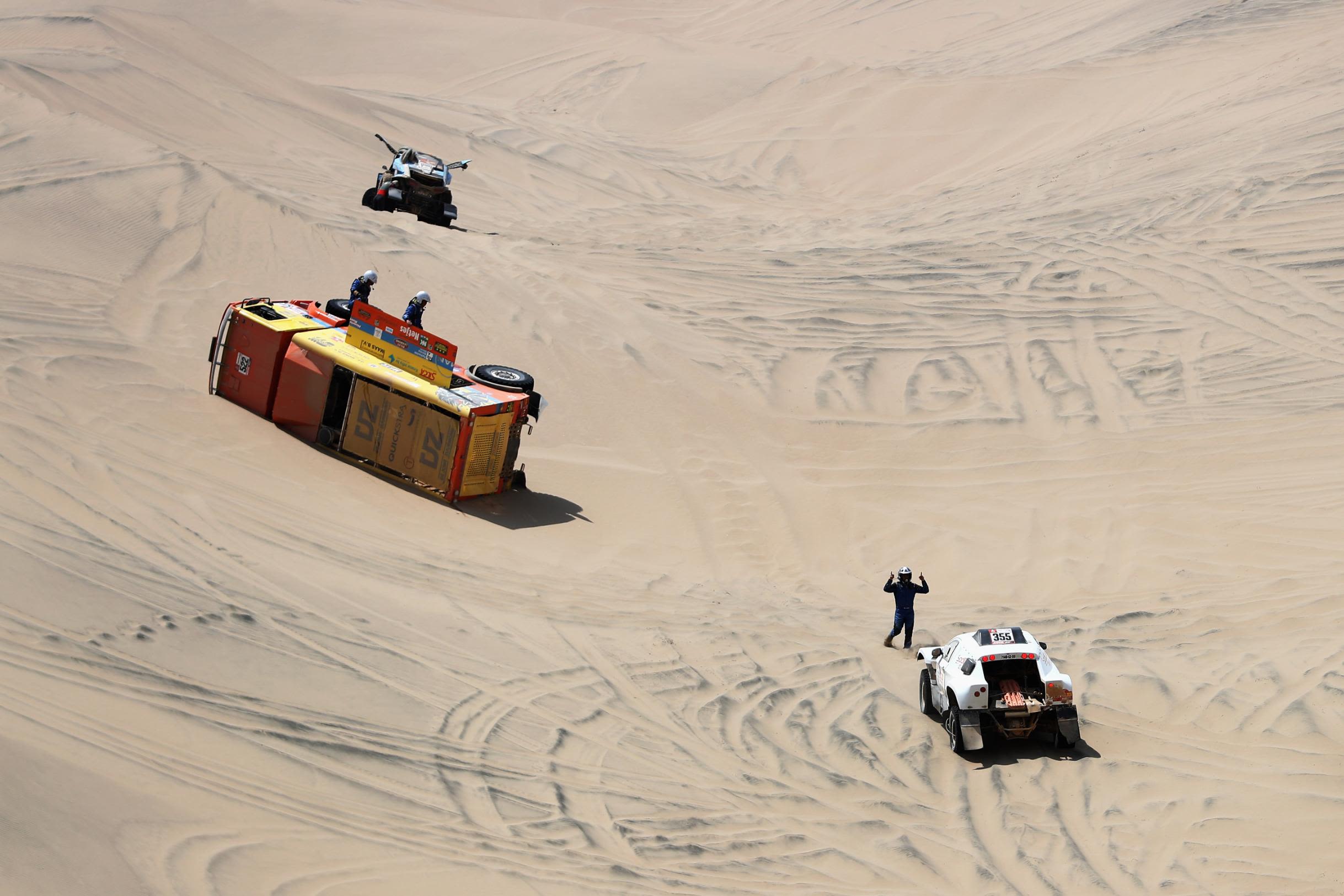 The truck of Gerrit Zuurmond, Jasper Riezebos and Klaas Kwakkel flips over as Philippe Boutron and Mayeul Barbet check on the Dutch trio.