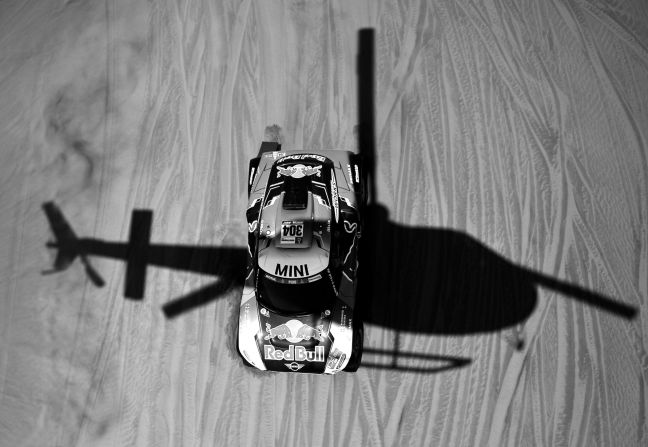 A helicopter casts is shadow over Mini driver Stephane Peterhansel and co-driver David Castera.